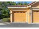 Attached one-car garage featuring neutral paint, reserved parking space, and tiled roof overhang at 2717 Via Cipriani # 620A, Clearwater, FL 33764