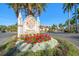 Grand Bellagio community sign surrounded by landscaping including red and white flowers at 2717 Via Cipriani # 623B, Clearwater, FL 33764