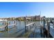 View of a private boat dock with boat lift, the water, and waterfront condos in the background at 2717 Via Cipriani # 623B, Clearwater, FL 33764