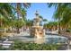 Beautiful tiered fountain adorned with lion statues, framed by swaying palms and manicured greenery at 2717 Via Cipriani # 623B, Clearwater, FL 33764