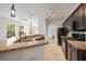 Modern kitchen with granite counters, black appliances, and a view into the living space and hallway at 2717 Via Cipriani # 623B, Clearwater, FL 33764