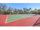 Well-maintained tennis court with green and red surface, surrounded by trees and upscale residences at 2717 Via Cipriani # 623B, Clearwater, FL 33764