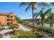 View of the waterfront pathway with palm trees and community homes and docks in the background at 2717 Via Cipriani # 623B, Clearwater, FL 33764