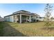 Beautiful backyard view showcasing the covered patio and meticulously maintained lawn for outdoor enjoyment at 3042 Marine Grass Dr, Wimauma, FL 33598