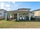 Inviting covered patio featuring lounge seating and a hanging chair, perfect for outdoor relaxation and entertaining at 3042 Marine Grass Dr, Wimauma, FL 33598