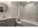 Elegant bathroom featuring marble tile, round mirror, a shower/tub combination for a luxurious experience at 3042 Marine Grass Dr, Wimauma, FL 33598