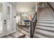 Inviting foyer with staircase and dining room visible through decorative front door at 3042 Marine Grass Dr, Wimauma, FL 33598