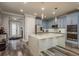 Modern kitchen with blue cabinets, stainless appliances, and a large center island at 3042 Marine Grass Dr, Wimauma, FL 33598