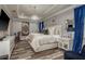 Beautiful main bedroom with hardwood floors, modern chandelier, TV, and tray ceiling at 3042 Marine Grass Dr, Wimauma, FL 33598