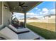 Relaxing covered patio with lounge chairs and an egg chair overlooking the well-manicured backyard at 3042 Marine Grass Dr, Wimauma, FL 33598