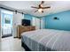 Bedroom featuring bright blue walls, ceiling fan, and sliding barn door to ensuite bathroom at 3142 Domino Dr, Holiday, FL 34691