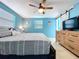 Bedroom showcasing a bed with a gray patterned quilt and a dresser with a TV at 3142 Domino Dr, Holiday, FL 34691