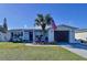 Beautiful home with green grass, palm tree with the American flag, and small rocking chairs at 3142 Domino Dr, Holiday, FL 34691