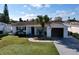 Well-kept home with a manicured lawn, a mature palm tree, and lovely front porch decor at 3142 Domino Dr, Holiday, FL 34691