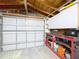 Well-lit garage with an automatic door, work bench, and ample storage solutions at 3142 Domino Dr, Holiday, FL 34691