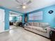 Living room featuring bright blue walls, tile floors, a sofa, and mirrored sliding doors at 3142 Domino Dr, Holiday, FL 34691