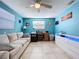 Living room featuring bright blue walls, tile floors, a sofa, and a desk with chair at 3142 Domino Dr, Holiday, FL 34691