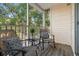 Relaxing screened balcony area with outdoor seating and a view of lush greenery at 3300 Haviland Ct # 304, Palm Harbor, FL 34684