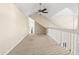 Spacious loft area with neutral carpet, vaulted ceiling and balcony railing at 3300 Haviland Ct # 304, Palm Harbor, FL 34684