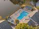 Aerial view of community pool and hot tub overlooking the lake at 3300 Haviland Ct # 304, Palm Harbor, FL 34684