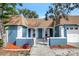 Charming home featuring a well-decorated front entrance with a combination of blue paint and tasteful landscaping at 3544 Landale Dr, Holiday, FL 34691