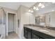 Bathroom featuring double vanity with granite countertops, decorative lights, and a glass door shower at 3568 Pine Ribbon Dr, Land O Lakes, FL 34638