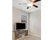 Neutral-toned bedroom with carpet, ceiling fan, and a modern TV stand, offering a cozy and contemporary feel at 3568 Pine Ribbon Dr, Land O Lakes, FL 34638