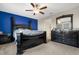 A well-lit bedroom featuring a blue accent wall, ceiling fan, and spacious dressers at 3568 Pine Ribbon Dr, Land O Lakes, FL 34638