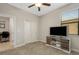 Neutral-toned bedroom with carpet, ceiling fan, and a modern TV stand, offering a cozy and contemporary feel at 3568 Pine Ribbon Dr, Land O Lakes, FL 34638