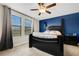 A spacious bedroom is brightly lit, featuring a ceiling fan and a decorative blue accent wall at 3568 Pine Ribbon Dr, Land O Lakes, FL 34638