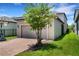 Exterior home view highlighting a two-car garage, lush lawn and brick paver driveway at 3568 Pine Ribbon Dr, Land O Lakes, FL 34638