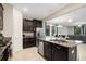 Kitchen featuring stainless steel appliances, dark cabinets and an island with granite countertops at 3568 Pine Ribbon Dr, Land O Lakes, FL 34638