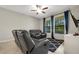 Comfortable living room featuring dual windows and leather reclining sofa at 3568 Pine Ribbon Dr, Land O Lakes, FL 34638