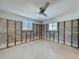 Unfinished bedroom featuring concrete walls, ceiling fan and natural light from windows at 4941 Waterside Dr, Port Richey, FL 34668