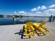 Waterfront property featuring dock with two yellow lounge chairs overlooking beautiful lake view and blue sky with clouds at 4941 Waterside Dr, Port Richey, FL 34668