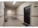 Well-lit hallway with neutral colors, leading to a black entry door with a welcome mat at 501 Knights Run Ave # 1203, Tampa, FL 33602