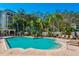 Community swimming pool with tropical landscaping and lounge chairs at 501 Knights Run Ave # 1203, Tampa, FL 33602