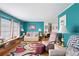 Inviting living room featuring vibrant teal walls, cozy seating, and stylish decor at 5125 Jo St, Zephyrhills, FL 33542