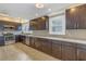 Modern kitchen with dark cabinetry, stainless steel appliances, granite countertops and wood-look tile flooring at 535 28Th N Ave, St Petersburg, FL 33704