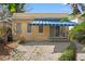 Back patio featuring an awning, sliding glass door, brick pavers, and tropical plants at 5807 N Branch Ave, Tampa, FL 33604