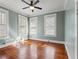 Light-filled bedroom with three windows, ceiling fan and beautiful hardwood floors at 5807 N Branch Ave, Tampa, FL 33604