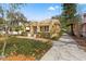 Side view of yellow bungalow with manicured landscaping, driveway and detached garage at 5807 N Branch Ave, Tampa, FL 33604