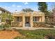 Charming yellow home with a symmetrical facade, manicured landscaping, and a welcoming entrance at 5807 N Branch Ave, Tampa, FL 33604