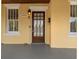 Close-up of the front door and porch of a yellow bungalow, showing the home's unique character at 5807 N Branch Ave, Tampa, FL 33604