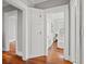 Hallway featuring original hardwood floors, painted in neutral colors with classic white trim at 5807 N Branch Ave, Tampa, FL 33604