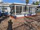 Enclosed back porch with screens, light blue siding and a gray tile roof; view of the yard at 6008 Memorial Hwy, Tampa, FL 33615