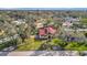 Aerial view of a home with red roof, green grass and mature trees at 612 Montezuma Dr, Bradenton, FL 34209