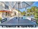 Outdoor dining set under a large umbrella next to a stunning pool in a lush backyard at 612 Montezuma Dr, Bradenton, FL 34209