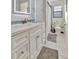 White tiled bathroom featuring a vanity with modern finishes and a decorative mirror at 612 Montezuma Dr, Bradenton, FL 34209