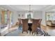 A dining room featuring a wooden table, wicker chairs, and stylish light fixture with French door views to the exterior at 612 Montezuma Dr, Bradenton, FL 34209